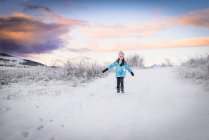Усміхнена дівчина йде зимовим пейзажем на заході сонця (Рила, Болгарія). — стокове фото