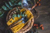 Overhead view of a rustic place setting with eucalyptus stems — Stock Photo