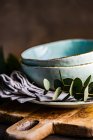 Stack of ceramic plates and bowls with eucalyptus stems — Stock Photo
