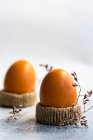 Zwei gekochte Eier in Eierbechern neben getrockneten Blumen — Stockfoto