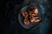 Organic pomegranate seeds on a stone plate — Stock Photo