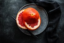 Кусочки розового грейпфрута на каменной тарелке — стоковое фото