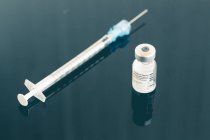 A vial of the Coronavirus vaccine and syringe on a table in a clinic — Stock Photo