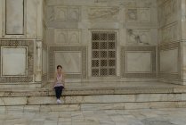 Mujer sentada en una pared en el Taj Mahal, Agar, Uttar Pradesh, India - foto de stock