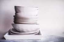 Montón de cuencos y platos minimalistas en una bandeja - foto de stock