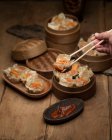 Person eating Shumai steamed Chinese dumplings with pork — Stock Photo