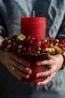 Primo piano di una donna che tiene una decorazione di candela di Natale — Foto stock