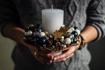 Крупный план женщины, держащей украшение рождественской свечи — стоковое фото
