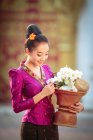 Ritratto di una bella donna che tiene un cesto con fiori freschi, Thailandia — Foto stock