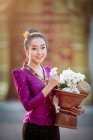 Portrait d'une belle femme tenant un bol avec des fleurs fraîches, Thaïlande — Photo de stock