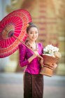 Retrato de uma bela mulher segurando uma cesta com flores frescas, Tailândia — Fotografia de Stock
