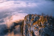 Uomo in piedi sulla cresta della montagna che si erge sopra il tappeto nuvoloso, Hallein, Salisburgo, Austria — Foto stock
