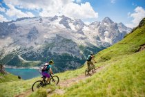 Man and woman mountain biking in the Dolomites, Val Gardena, South Tyrol, Italy — Stock Photo