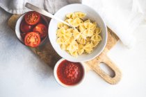 Gesundes Dinner-Konzept mit handgemachter Farfalle-Pasta mit Tomatensauce auf Betontisch — Stockfoto
