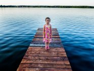 Ragazza in piedi su un molo di legno in un lago, Polonia — Foto stock