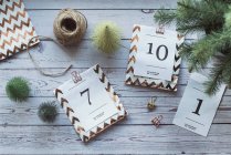 Overhead view of gifts for an advent calendar next to Christmas decorations — Stock Photo