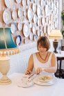 Жінка сидить в ресторані їсть пельмені — стокове фото