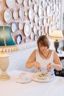Жінка сидить в ресторані їсть пельмені — стокове фото