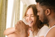 Mixed race couple sharing a glass of milk — Stock Photo
