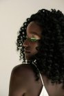 Retrato de una hermosa chica africana con maquillaje verde mirando por encima de su hombro - foto de stock