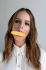 Portrait of a woman with a banana in her mouth — Stock Photo