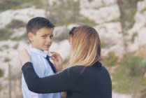 Retrato de uma mãe ajustando a gravata de seu filho — Fotografia de Stock