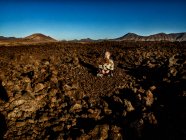 Ragazza seduta in un campo di lava, Lanzarote, Isole Canarie, Spagna — Foto stock