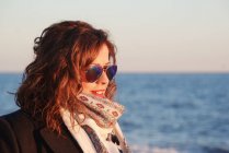 Retrato de uma bela mulher usando óculos de sol em pé à beira-mar, Málaga, Andaluzia, Espanha — Fotografia de Stock
