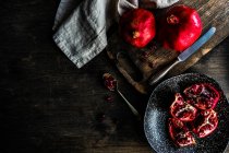 Frutas de romã orgânica com suas sementes no prato como um conceito de alimento orgânico — Fotografia de Stock