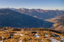 Mountainbikerin in alpiner Landschaft im Spätherbstschnee, Gastein, Salzburg, Österreich — Stockfoto