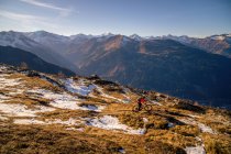 Mountainbikerin in alpiner Landschaft im Spätherbstschnee, Gastein, Salzburg, Österreich — Stockfoto