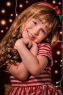 Portrait of a smiling girl in front of Christmas lights — Stock Photo