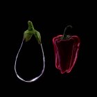 Silhouette of an aubergine and red pepper against black background — Stock Photo