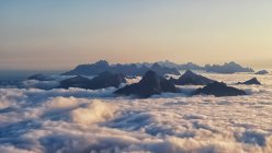 Picos de montanha subindo através de tapete de nuvens, Lofoten, Nordland, Noruega — Fotografia de Stock