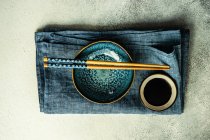 Luogo di impostazione per la cena con cibo asiatico con ciotola e bacchette su sfondo rustico — Foto stock