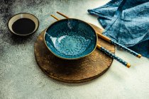 Platz für ein Abendessen mit asiatischem Essen mit Schüssel und Essstäbchen auf rustikalem Hintergrund — Stockfoto