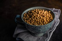 Ceramic bowl full of raw cheakpeas on rustic background with copy space — Stock Photo