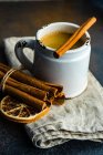 Mug of hot chocolate with cinnamon sticks and orange on rustic background with copy space — Stock Photo