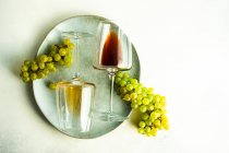 Verre de vin géorgien Rkatsiteli en verre et raisin cru frais sur table rustique — Photo de stock