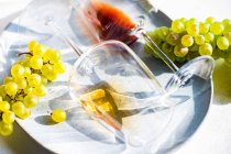 Copo de vinho georgiano Rkatsiteli em vidro e uvas cruas frescas sobre mesa rústica — Fotografia de Stock