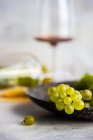 Copa de vino georgiano Rkatsiteli en copa y uva fresca cruda en mesa rústica - foto de stock