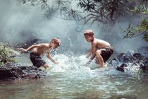 Dos chicos lavándose en un río, Tailandia - foto de stock