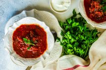 Традиційний українець суп з жука Червоний Боршт подається в мисці на сільському столі. — стокове фото