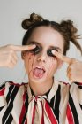 Porträt einer Frau, die sich Brombeeren auf die Augenlider drückt, konzeptionelle Hautpflege — Stockfoto