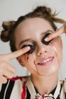 Porträt einer Frau, die sich Brombeeren auf die Augenlider drückt, konzeptionelle Hautpflege — Stockfoto