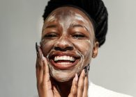 Porträt einer lächelnden Frau mit Gesichtsmaske — Stockfoto