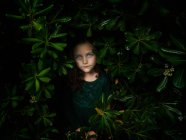 Retrato de uma menina bonita em pé entre arbustos — Fotografia de Stock
