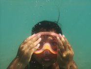 Portrait of a girl swimming underwater wearing a diving mask, Italy — Stock Photo
