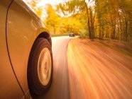 Автомобиль мчащийся по дороге осенью, США — стоковое фото