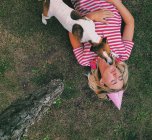 Собака стоїть над жінкою, що лежить на траві спить — стокове фото